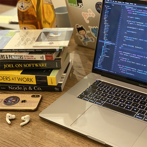 Desk with programming books and computer